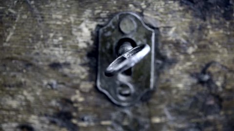 Close up of key and lock of  vintage wooden chest. Slow sliding zoom motion. Concept of antique furniture, security and history.