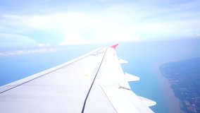 View of a blue sky and a wing through airplane window.