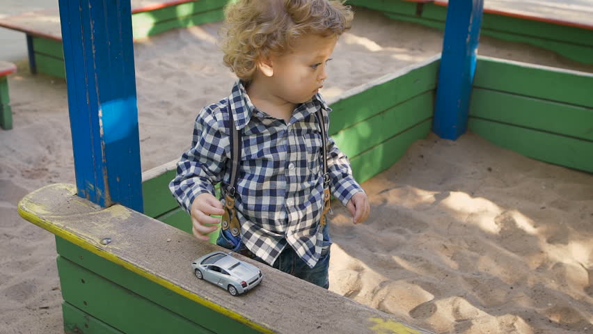 Happy little boy playing on the playground. He is very cute and naive. 