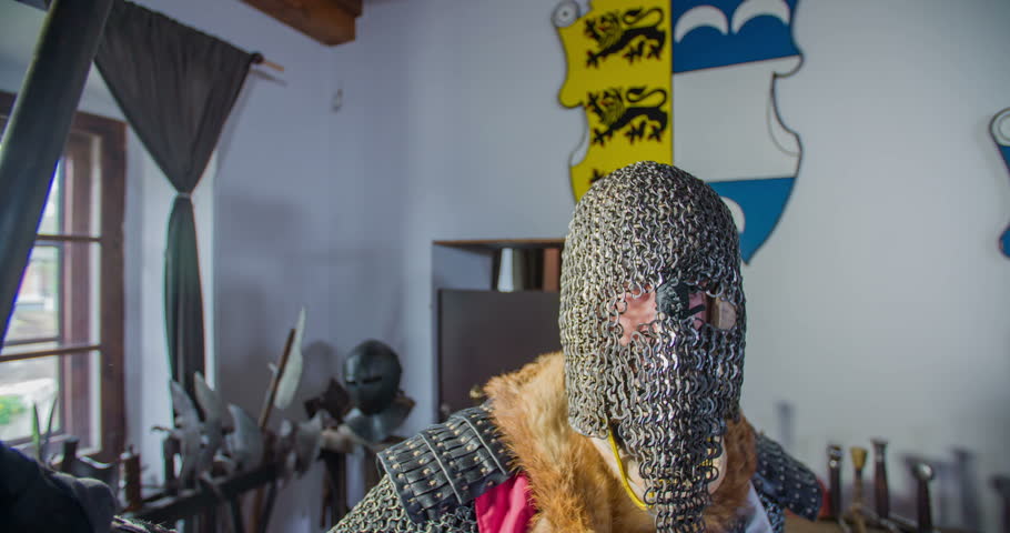 A knight is almost fully dressed. He just needs to put on an armour and then he is ready to go to a battle. Close-up shot.