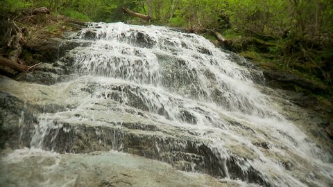 Water cascades down rocky steps in slow-motion