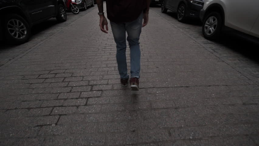 A young, black male walks through Brooklyn. New York, NY - March, 2016