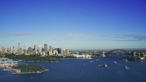 Aerial Sydney Harbour approaching the Harbour Bridge and Sydney Opera House on a beautiful clear sunny blue day.

