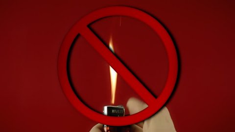 A big red stop sign appears on a scene: frantically operating a cigarette lighter. Colorful close-up shot on red background.
