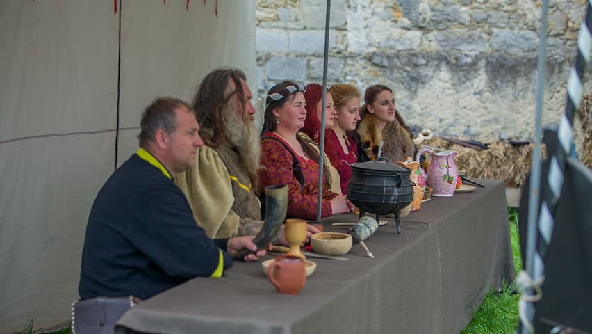 Ladies of a royal family are clapping when one of the knights won a tournament. The men part is sitting still. Wide-angle shot.