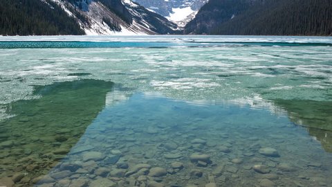 4K Time lapse close up of broken ice moving by and zoom out of Lake Louise in spring. Lake Louise is one the most visited lakes at Banff National Park, Alberta, Canada.