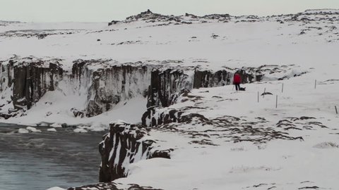 Time lapse zoom out of Sellfoss waterfall in Iceland in wintertime with a photographer making pictures