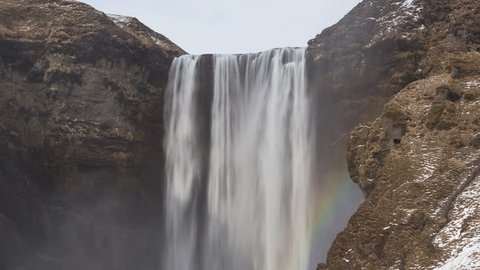 4K Time lapse close up of Skogafoss waterfall in Iceland in wintertime with a rainbow