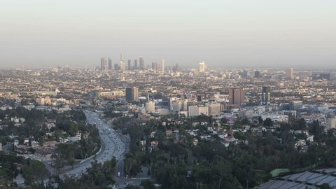 LOS ANGELES, USA - APR 15, 2015: 4k time lapse zoom in of sunset view of downtown Los Angeles from the Hollywood Hills with Interstate 101 in the foreground.