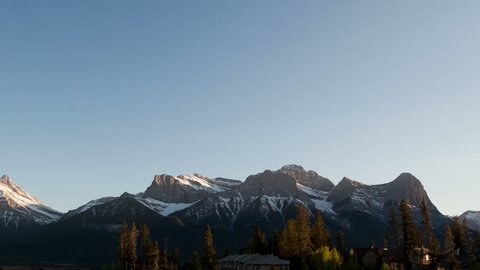 4K Time lapse pan shot of the Three Sisters mountains in Canmore, Alberta, Canada's Rocky Mountains at sunset