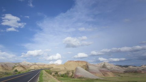 4K Time lapse pan and tilt shot Badlands Loop Road through the colorful Yellow Mounds area with clouds passing by a blue sky at Badlands National Park in South Dakota
