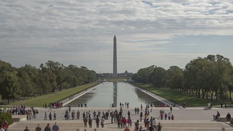 WASHINGTON D.C., USA - OCT 14, 2012: Time lapse close up crowd of people walking around at Washington Monument view from Lincoln Memorial with dark cloudes in the sky
