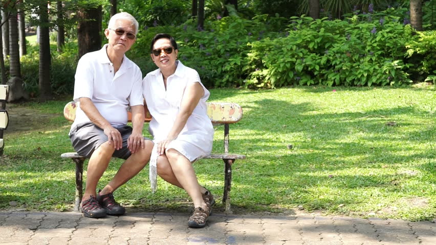 Asian senior couple stay together in nature. Talking and touching with love