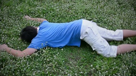 An Asian Thai man drop dead on the grassy ground field and twitching in HD
