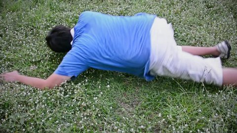 An Asian Thai man guy drop dead on the grassy ground field in HD
