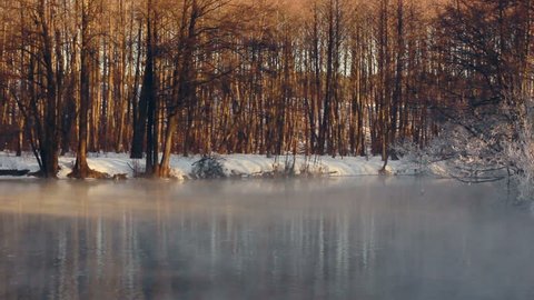 Winter wonderland. Winter landscape. Fog over forest river in winter. River in winter forest