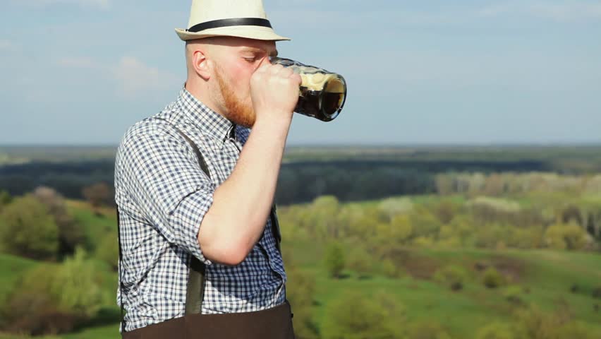 A man in a spring day enjoying a delicious dark beer.