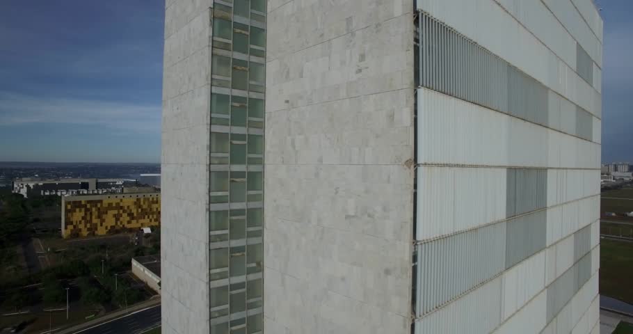 Brasilia aerial sideways move revealing view between the National Congress (Congresso Nacional) towers with Esplanada dos Ministerios in the background