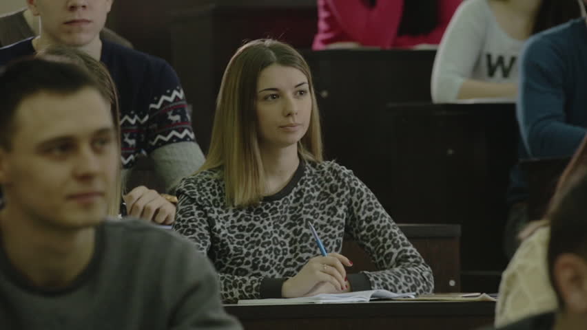Girl student pulls his hand and answers the question in the auditorium