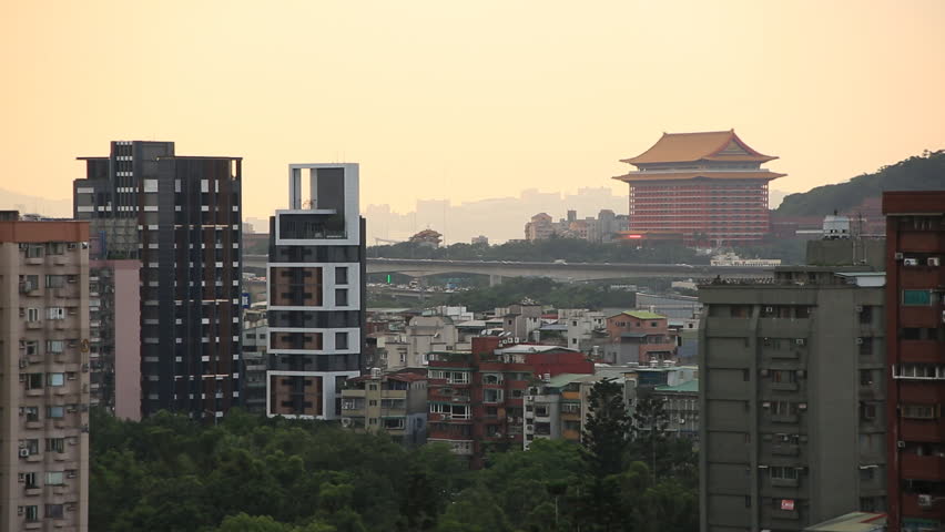 An airplane flying over Taipei city at sunset