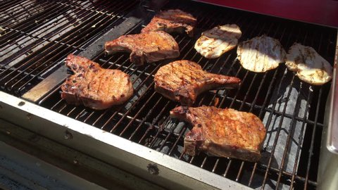 Pork tenderloin cooking on grill in sunshine 4k