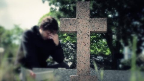 Man crying On Tombstone In Cemetery Before Leaving. Man crying In the Tombstone of a Cemetery and then he leaves the place