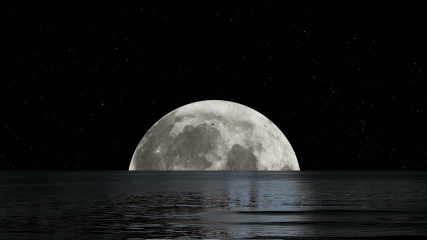 A huge, full Moon rising on a dark starry night.  