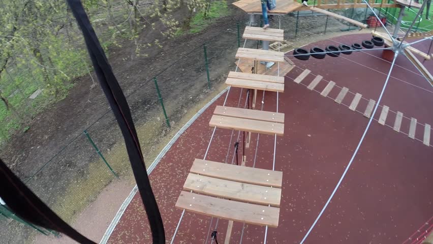 Man goes on dangerous rope bridge, boy and girl wait to him, FPV