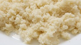 Cooked couscous served on the plate slow tilt close-up 4K 3840X2160 30fps UHD video - Tasty north African semolina prepared and served on plate 4K 2160p tilting footage