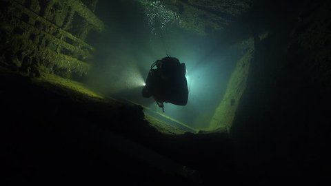 Scuba diver swims inside the shipwreck corridor - Umbria shipwreck, Red sea, Sudan.
Diver silhouette at backlight.