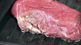 Beef Steak in a pan (selective focus) as high detailed 4K UHD footge
