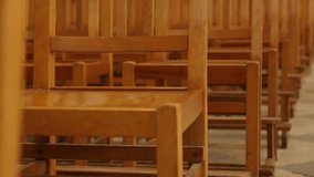 Empty chairs in a row in the church close-up tilting 4K 2160p 30fps UltraHD footage - Wooden seats in cathedral empty without people slow tilt 4K 3840X2160 UHD video