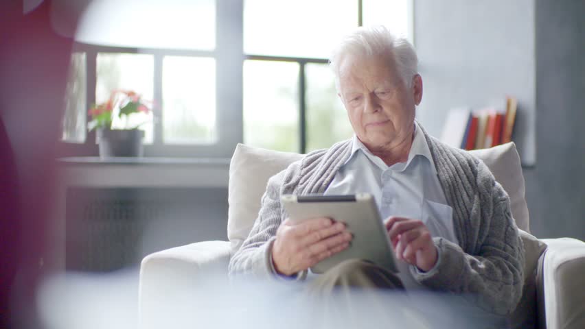 old man is using tablet computer at home Royalty-Free Stock Footage #16789567