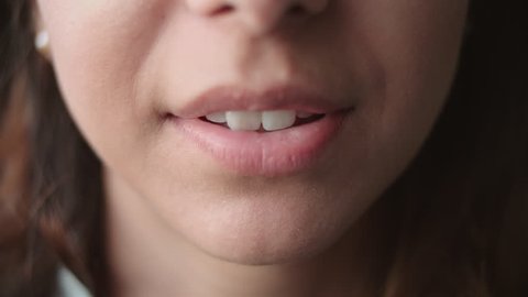 Detail shot of woman's mouth as she speaks and smiles