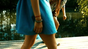 Three happy young Caucasian teen girls standing on a wooden pier. Summer holidays, friendship concept. 60 FPS slow motion shot. Blackmagic URSA Mini RAW graded footage