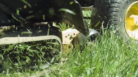 Lawn mower blades cutting grass in slow motion