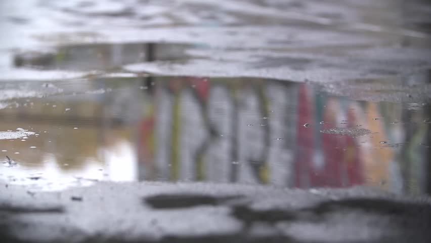 Close up slow motion shot of legs of a runner in sneakers. Male sports man jogging outdoors in a park, stepping into muddy puddle. Single runner running in rain, making splash. Royalty-Free Stock Footage #16808320