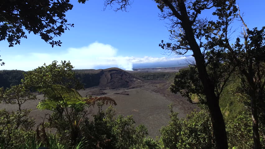 Barren volcano crater, with forest and blue sky background - Hawaii, Big Island, slider shot