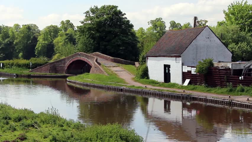 Building next to bridge and canal, reflections seen in the water