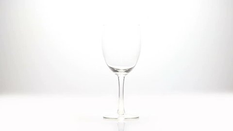 Wine being poured into a glass in slow motion on a white background