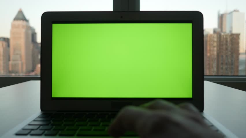 laptop computer with isolated green screen background. modern city office desk view. working at home. green chroma key background