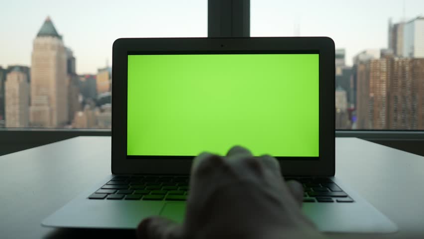 laptop computer with isolated green screen background. modern city office desk view. working at home. green chroma key background