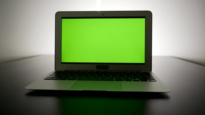 laptop computer with isolated green screen background. modern city office desk view. working at home. green chroma key background