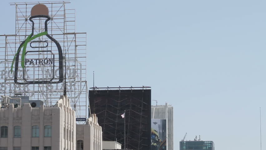 Tilt Down to Hollywood & Vine. Tilt down to an epic view looking South on Vine Street towards Hollywood Boulevard in Los Angeles, California. Visible in the distance is vehicle and pedestrian traffic.