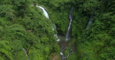 Three powerful waterfalls with water flowing into a big river. Shot in a tropical jungle. Video Stok