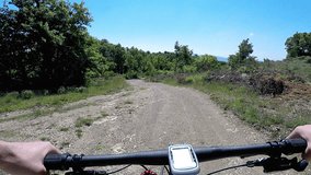 Man going on mountain bike on dirt trail. Original point of view, view in first person. Video form action camera an steady cam for stabilization.