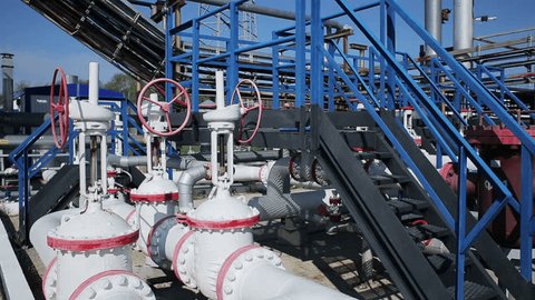 Modern facility with pipes or powerful process area at the oil depot or tank farm. Rock-oil extraction for supply. Engineering complex for refining and delivery. Dolly outdoors in sunny summer. Nobody
