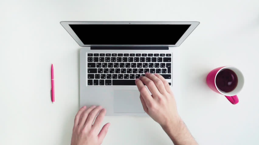 Top view of white desk with office supplies. Man using his laptop computer, typing, surfing and drinking coffee Royalty-Free Stock Footage #16858324