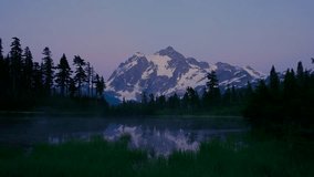 Landscape video. Dawn over the lake. Snowy mountain peak is reflected in the water. The forest on the lake. The singing of morning birds. 4K, 3840*2160, high bit rate, UHD. Mt. Baker. Washington state