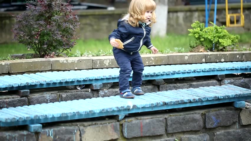 curly-haired boy is jumping with her mother